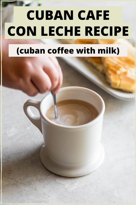 A white mug with cuban cafe con leche with a hand stirring with a spoon and cuban toast in the background and the words "cuban cafe con leche recipe (cuban coffee with milk)" in the foreground Cuban Dessert Recipes, Cuban Toast, Cafe Con Leche Recipe, Cuban Coffee Recipe, Cuban Espresso, Cubano Coffee, Café Cubano, Drinks Liquor, Cuban Desserts