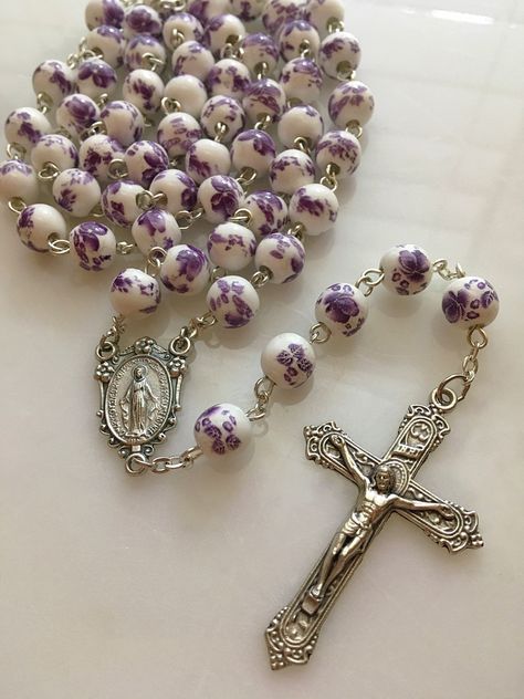 Handmade Blessed Virgin Mary Miraculous Medal rosary made with 8mm white & purple ceramic floral beads. Made with a silver Miraculous Medal center with flower accents and an ornate Victorian style made in Italy crucifix. *The holy card is not included. Rosary Necklaces, Flower Rosary, Purple Ceramic, Blessed Mary, Rosary Beads Catholic, Praying The Rosary, Holy Rosary, Catholic Rosary, Rosary Necklace