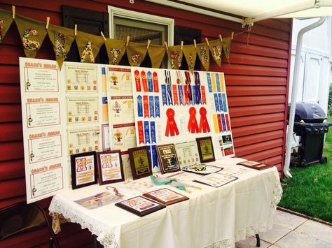 Graduation award display table Graduation Award Display, Grad Party Achievement Table, Awards Display Grad Party, Display Ribbons Awards, How To Display Medals At Grad Party, Displaying Ribbons Awards, Graduation Picture Boards, Graduation Party Picture Display, Graduation Display