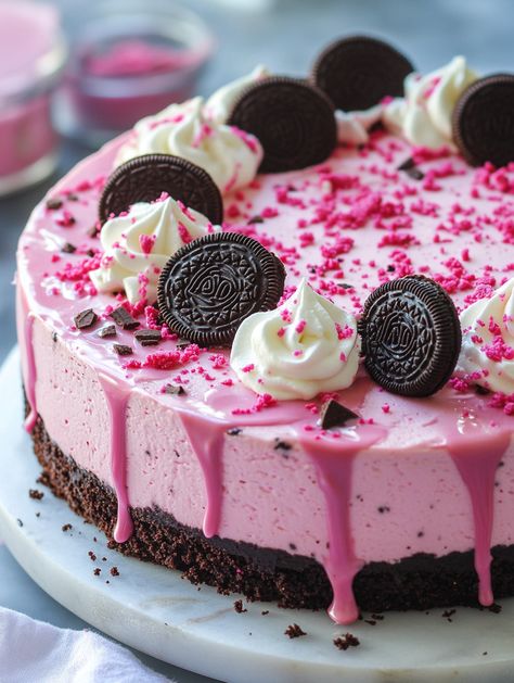 Ingredients:  For the crust:  - 2 cups Oreo crumbs - 1/4 cup unsalted butter, melted For the cheesecake: - 24 oz (680g) cream cheese, softened - 1 cup granulated sugar - 1 cup sour cream - 1 teaspoon vanilla extract - 3 large eggs - 2 tablespoons cocoa powder - 1 teaspoon pink food coloring - 1/2 cup crushed Oreos For the drip: - 1 cup white chocolate chips - 1/2 cup heavy cream For decoration: - Whipped cream - Mini Oreos - Pink velvet cake crumbs - Sprinkles Pink Cheesecake, Pink Velvet Cake, Mini Oreos, Pink Velvet Cakes, Dessert Hacks, Candy Birthday Cakes, Pink Food, Delicious Deserts, Crushed Oreos