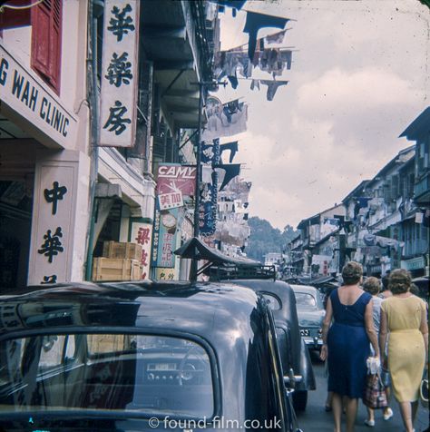 A street in Singapore taken in the early 1960s. Interesting to see the clothes hanging out to dry from the houses above the shops and the mingling of English and Chinese text on the street signs. Chinese Text, History Of Singapore, Beaches Film, Nature Film, Singapore Photos, Clothes Hanging, Film Home, Famous Landmarks, Street Signs