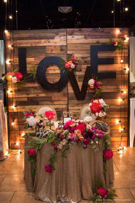 A sweetheart table one could only dream about! Nicole Ha Design styled our Reclaimed Barn Wood Walls, Love monogram letters, and market lights. Napa Valley Linens sequin tablecloth adds the perfect amount of sparkle to this Casa Real tablescape! Market Lights, Ideas Aniversario, Reception Backdrop, Wedding Reception Backdrop, Sequin Tablecloth, Wood Walls, Winter Decoration, Valentine Wedding, Sweetheart Table