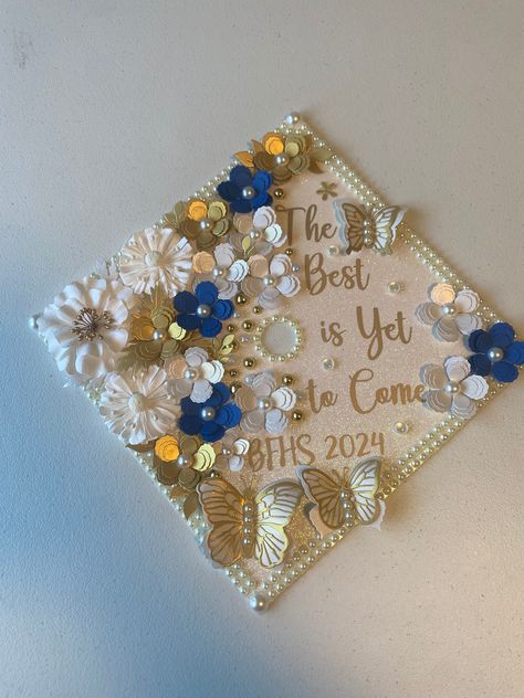 Hi everyone! this graduation cap topper is the perfect addition to your special day! It is made with heavy glitter card stock and permanent vinyl for the text. The paper flowers are all handmade by me and are what make my graduation cap toppers unique and elegant. This cap is made of high quality, durable materials that will keep you sparkling throughout your special day! How to attach to your graduation cap: There are double sided adhesive strips on the back, just peel off the backing and stick Gold Graduation Cap, Graduation Cap Designs Dedicated To Parents, Graduation Cap Designs Grandma, Graduation Cap Designs Loved Ones, Graduation Caps Dedicated To Parents, Customizable Graduation Cap Topper, Creative Senior Pictures, Custom Graduation Caps, Graduation Cap Decoration Diy