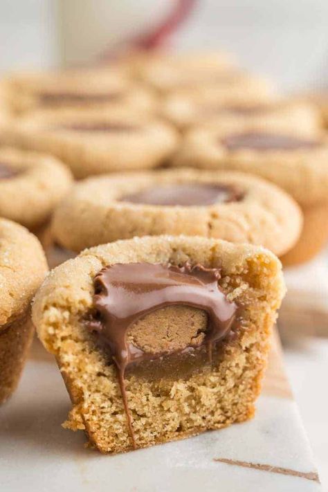 These peanut butter cup cookies are a unique twist on the classic Christmas treats, where the traditional Hershey's kisses are replaced with mini Reese's cups for a double dose of peanut butter delight. These cookies are perfect for those who can never have enough peanut butter. Try them today and enjoy an extra burst of flavor in every bite! Peanut Butter Cookies Cups, Reese’s Peanut Butter Cup Stuffed Chocolate Chip Cookies, Peanut Butter Cup Cookies Allrecipes, Peanut Butter Temptations Reeses, Recees Peanut Butter Cup Recipes, Reese’s Peanut Butter Temptations, Reese Cup Bars, Cookies With Mini Peanut Butter Cups, Cookies With Mini Reese Cups