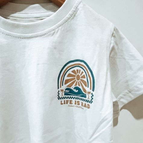 Bring a wave of positivity to your little one's closet with our 'Life is Rad' Kids Tee. This t-shirt, offering a relaxed and true-to-size fit, is perfect for kids on the move. Made from 100% organic cotton, it guarantees comfort and eco-friendliness, aligning with your sustainable lifestyle. With its unique design originating from Phillip Island, Australia, and its careful handcrafting in Bali, this tee is a blend of global quality and local charm. It's not just a tee, it's a statement of cool c Surf Shirt Design, T Shirt Design Ideas Creative, Kids Tshirt Designs, Unique Shirts Design, Minimal Shirt Design, Fashion Sustainability, Devine Design, Cool C, Phillip Island