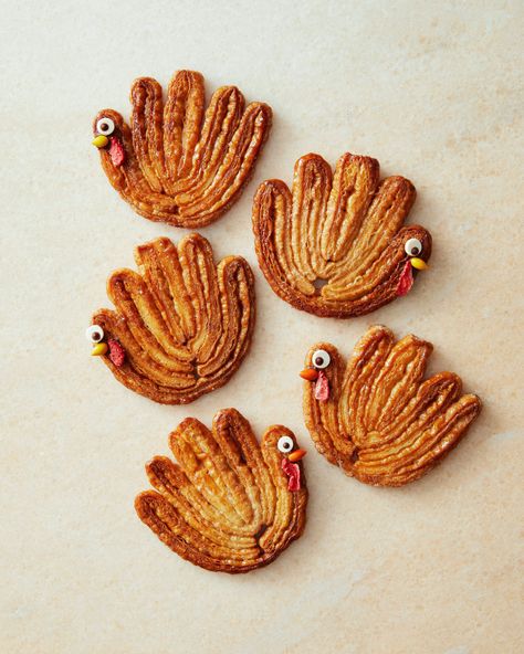 Puff Pastry Turkeys | Serve these palmier cookies honoring the Thanksgiving turkey, and even vegetarians can have a taste. Sprinkle store-bought puff pastry with cinnamon sugar and shape the five "feathers" by folding the dough, then slice and bake till crisp. A few candy decorations complete the turkey's face.  #food #recipe #marthastewart #thanksgiving Mini Thanksgiving Desserts, Cute Thanksgiving Desserts, Palmier Cookies, Thanksgiving Food Desserts, Thanksgiving Treats, Frozen Puff Pastry, Puff Pastry Recipes, Thanksgiving Desserts, Fun Treats