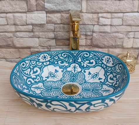 Introducing our exquisite Moroccan Oval Ceramic Wash Basin, a fusion of artistry and functionality that brings the timeless beauty of Moroccan craftsmanship to your space. Measuring 30cm in diameter, this meticulously handcrafted basin is a stunning addition to any bathroom or living area, marrying traditional design with modern utility. Each oval basin is a testament to the skill of Moroccan artisans, who have mastered the art of ceramic creation for generations. The basin showcases intricate p Clay Sinks, Ceramic Wash Basin, Moroccan Bathroom, Ceramic Kitchen Sinks, Modern Utility, Van Conversion Interior, Moroccan Culture, Countertop Basin, Sink Countertop