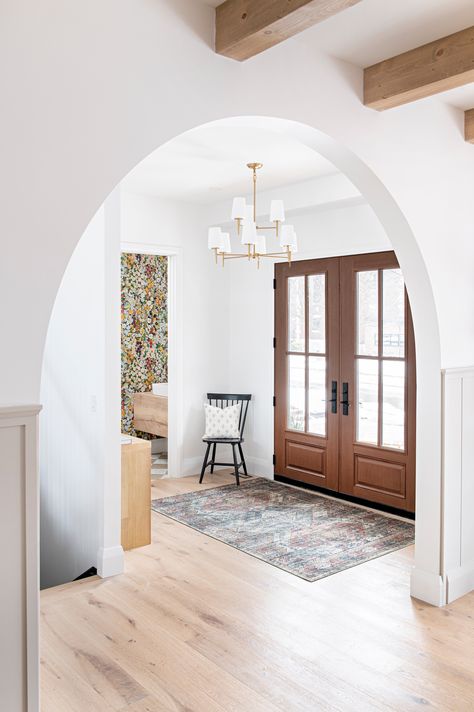 Front entry way with a big rounded archways Arched Cased Openings Between Rooms, Rounded Archways In Homes, Faux Archway, Arched Cased Opening, Curved Archway In Home, Arched Hallway Entryway, Entry Way Paint Colors Foyers, White Ranch Style House Exterior, White Ranch Style House