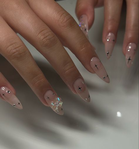 Minimal Festive Nails, Almond Nails With Bow Charm, Almond Nails Designs With Charms, Short Nails With Bow Charm, Chrome Nails Gems, Bow Gem Nails, Oval Nails With Rhinestones, Chrome Nails With Bow, Nails With Ribbon Design