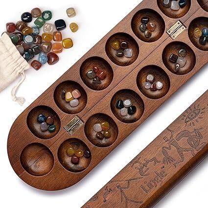 Amazon.com: Deluxe Mancala Set: Real Wood Hinged Board with 48 Natural Mixed Natural Gemstone - Authentic African Petroglyphs, Foldable Design for 2-Player Strategy Game : Toys & Games Mancala Board Design, African Board Games, Mancala Board, Board Game Components, African Petroglyphs, Antique Board Games, Wood Hinges, Vintage Props, The End Game