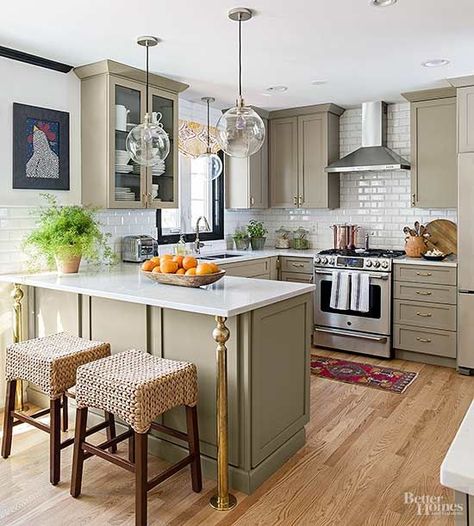 Moving the sink beneath a window gave the kitchen a harder working U-shape layout. Greige cabinets contrast white quartz countertops and a subway tile backsplash. The tile was reasonably priced, so they took it up to the ceiling for a sense of height. Brass cabinet hardware (a vintage eBay lot) and columns on the breakfast bar add age./ Open Concept Kitchen Living Room Raised Ranch, Kitchen Diy Makeover, تصميم داخلي فاخر, U Shaped Kitchen, Kitchen Designs Layout, Classic Kitchen, Kitchen Remodel Before And After, Kitchen Farmhouse, Interior Modern