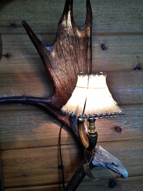 DO NOT BUY BEFORE contacting us to get the LOWEST price available!  Antler Carvings at Great Prices! Workmanship is GUARANTEED! Handcrafted in the USA. The Moose Antler Wall Sconce Handcrafted Moose Antler Art Antler Lighting Antler Decor Moose Antler Carvings Moose Antler Carvings  Eagle Carving  Eagle Sculpture The Moose Antler Wall Sconce is a magnificent looking antler light with a handmade rawhide shade. It is a beautiful work of antler art done by a true Antler Carving Artisan with over 30 Moose Antler Decor, Antler Light Fixtures, Antler Wall Sconces, Shabby Chic Cabin, Antler Lighting, Eagle Carving, Eagle Sculpture, Antler Carving, Antler Decor