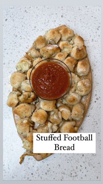 Beth Ann | Style Blogger on Instagram: "Stuffed Football Bread 🏈 This is an easy appetizer to serve at your NFL playoff watch parties! I served it on a football shaped board I found on Amazon. All are linked in my bio⬆️. Pre made pizza dough Cut up mozzarella cheese sticks Garlic butter Parmesan Marinara sauce Roll the cut up cheese in the dough. Place into a football shape. Cover in garlic butter. Cook at 400 for 15-20 minutes. Add more garlic butter, Parmesan and marinara for dipping Football Shaped Appetizers, Football Bread, Mozarella Balls, Mozzarella Cheese Sticks, Bread Shaping, Garlic Cheese, Pizza Bites, Cheese Sticks, Monkey Bread