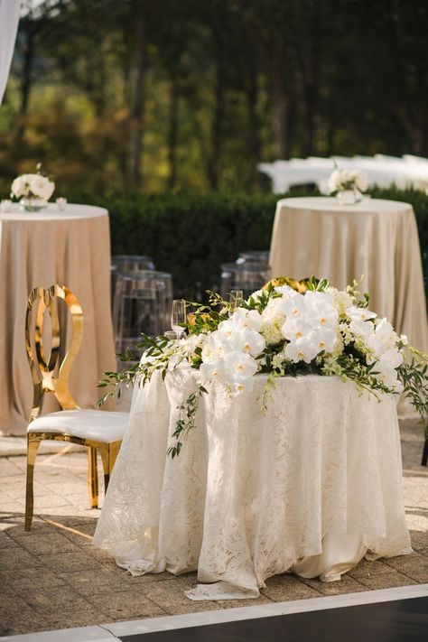 A cascading arrangement of orchids & greenery was the perfect choice for this luxe sweetheart table 💛 Orchid Sweetheart Table, Wedding Flowers White And Green, Green Wedding Theme, Sweetheart Table Flowers, Wedding Flowers White, Outdoor Wedding Flowers, Gold And White Wedding, White Wedding Reception, Wedding Sweetheart Table