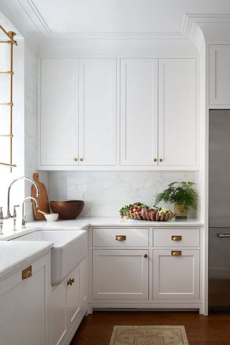 a beautiful white farmhouse kitchen with shaker cabinets, brass handles, crown molding that connects the cabinets with the ceiling and makes the space look higher Kitchen Brass Hardware, Crown Molding Kitchen, Brass Kitchen Hardware, Molding Design, Grey Kitchen Designs, Marble Backsplash, Shaker Cabinets, Cup Pulls, Kitchen Hardware