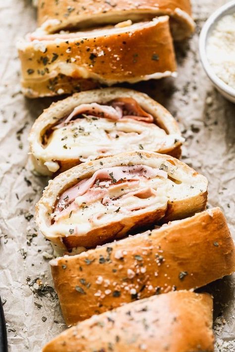 With just five ingredients, you can whip up our favorite easy lunch: Ham and Cheese Stromboli. We take frozen bread or pizza dough, layer it up with salty ham, gooey white American cheese, and then roll it up and bake. Simplicity at its finest, and oh-so cheesy. HAM AND CHEESE STROMBOLI! Ham And Cheese Stromboli Recipe, Ham And Cheese Stromboli, Cheese Stromboli Recipe, Cheese Stromboli, White American Cheese, Stromboli Recipe Easy, Rhodes Bread, Refrigerated Pizza Dough, Stromboli Recipe