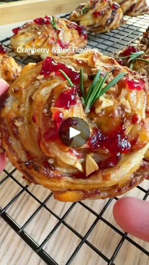 1K views · 102 reactions | Delicate, creamy, and bursting with festive flavor... 🧀✨ these cranberry and brie flowers are the perfect addition to your 12 Days of Christmas Appetizers! Beautiful, simple, and a guaranteed hit at your holiday gatherings. 🎄💐 Thanks to @mumsfoodies on TikTok for this stunning recipe.

Recipe for Cranberry and Brie Flowers

Ingredients:

1 sheet puff pastry, thawed

1 wheel of brie cheese, cut into small cubes

½ cup cranberry sauce

Fresh rosemary or thyme for garnish

Instructions:

1. Preheat oven to 375°F (190°C) and grease a mini muffin tin.

2. Cut puff pastry into small squares and gently press them into the muffin tin, creating little cups.

3. Place a cube of brie into each pastry cup, followed by a small dollop of cranberry sauce.

4. Bake for 12–15 Brie And Cranberry Puff Pastry Flowers, Cranberry And Brie Flowers, Brie And Cranberry Flowers, Cranberry And Brie Puff Pastry Wreath, Brie Pinwheels, Christmas Snacks Gifts, Cranberry And Brie, Cranberry Wreath, Xmas Appetizers