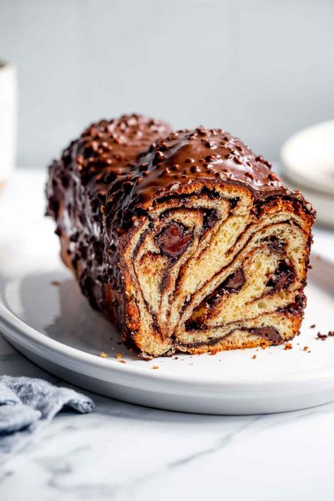 Chocolate Babka is a gorgeous, sweet braided bread. It's buttery, soft, and filled with chocolate. Perfect for holidays and celebrations. It is perfect for a crowd, this recipe makes two babkas and serves 16 people. It is also easy to keep at room temperature and easy to freeze. #jernejkitchen #babka #chocolatebabka #christmas #hannukah #baking #chocolate Babka Recipe, Chocolate Babka, Baking Chocolate, Braided Bread, Chocolate Spread, Blanched Almonds, Cinnamon Powder, Chocolate Glaze, Chocolate Cinnamon