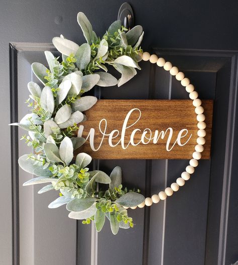 "*This neutral wood beaded hoop wreath is a perfect way to welcome guest for any season! Hang this piece on your front door or in your home for guests to see!  *The wood is stained and the wording is painted of your color choice! The neutral wood beads are threaded through the metal hoop (not glued on). The floral and wood are securely attached to the metal hoop. This sign can be for indoor or outdoor use. I apply an outdoor sealer on the wood. The back of the wood is finished just like the fron Wreath Rings Ideas, Beaded Door Hanger, Front Door Hangers Wooden, Spring Welcome Sign Front Door, Spring Decor Ideas For The Home, Painted Door Signs Ideas, Wreath Alternatives For Front Door, August Wreaths For Front Door, Wooden Ball Wreath