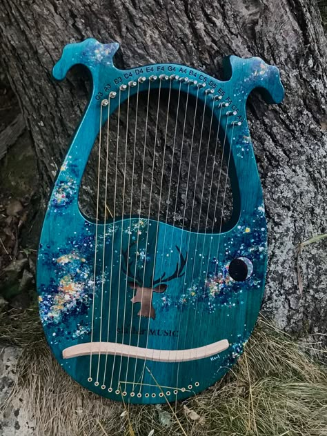 This beautiful, hollow-bodied mahogany 16-string lyre harp is tuned to a major C scale that covers a little over two octaves. The tuning pegs are labeled for the correct notes. The sound hole shape is a stag cutout and the overall color is a rich, deep blue-green that lets a touch of the natural grain show through. I hand paint the star feilds and nebulae, and the crescent moon is an overlay of genuine abalone shell, all of which will be very similar to those in the photos unless you let me know Moon Lyre Harp, Lyre Harp Aesthetic, Lyre Aesthetic, Lyre Instrument, Lyre Harp, Instruments Art, Sky Design, Ukelele, Hand Paint