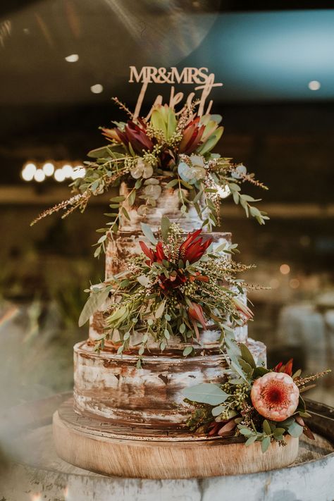 This is the ultimate Australian wedding cake: three tiers, native Australian florals, naked icing and sat atop a barrel. Wedding Cake Australian Native, Rustic Australian Wedding, Australian Bush Wedding, Bush Wedding Australian, Australian Natives Wedding, Australian Native Wedding, Wildflower Cake, Bush Wedding, 18th Cake