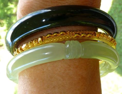 A combination of two basic Chinese jade bangle bracelets, classic green carved and deep deep almost black green with a 24k gold "spacer" bangle.  I love the yin and yang of the light translucent green jade and yang "black" jade, simple jade from the earth, with expensive 24k gold.  #13 in the travel collection. Gold Jade Jewelry, Jade Bangle Outfit, Jade And Gold Jewelry, Jade Bracelet Aesthetic, Green Jade Aesthetic, Bangle Outfit, Clothing Aesthetics, Bracelets Outfit, Girly Bracelets