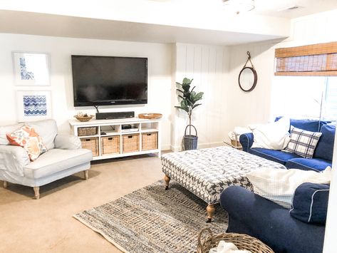 Navy and white basement  makeover with a nautical feel. Bamboo shades, Denim sofa, Blue and white striped side chair. Ikea furniture  #shiplapwalls #shiplapbasement #basementmakeover #whitewallsbasement #blueandwhitebasement #beachcottgefamilyroom #beachcottage #casualcottagedecor #basementideas Nautical Basement, White Basement, Fabric Coffee Table, Denim Sofa, Vertical Shiplap, Basement Reno, Basement Makeover, Bamboo Shades, Striped Cushions