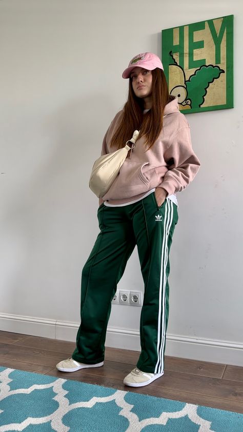 Lacoste cap, pale pink hoodie, green satin Adidas pants, Adidas Gazelle, crossbody bag #ootd #ootdfashion #outfits #outfitideas #streetstyle #style #stylish #styleblogger #styleideas #fashion #lookoftheday Pink And Green Winter Outfit, Green Adidas Pants Outfit, Green Track Pants Outfit, Pink Cap Outfit, Green Sweatpants Outfit, Green Adidas Pants, Green Joggers Outfit, Adidas Street Style, Jogging Adidas