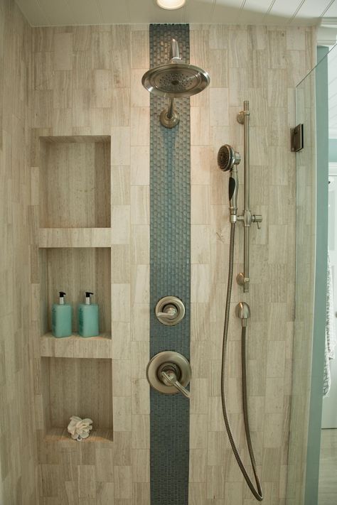 An accent stripe of glass tiles adds interest to this neutral shower. Sleek niches provide storage for shower essentials, and dual shower heads create a luxurious atmosphere. Bathroom Niche, Shower Plumbing, Desain Pantry, Shower Niche, Bathroom Remodel Shower, Bathroom Reno, Shower Shelves, Trendy Bathroom, घर की सजावट