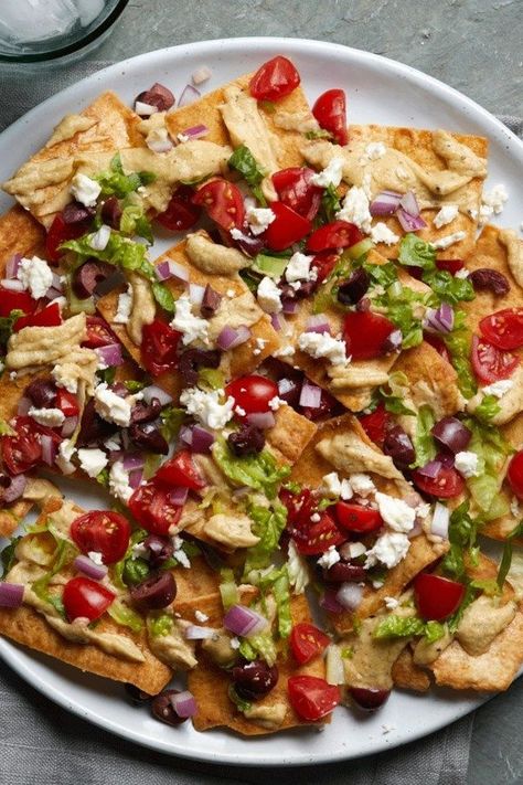 This vegetarian nacho recipe is a fun combination of two favorites—nachos and Greek salad. It uses whole-grain pita chips instead of the tortilla chips used in traditional nacho recipes, and it's loaded with the classic fresh vegetables in Greek salad as well as creamy hummus and salty feta cheese. #lunch #lunchideas #healthylunchideas #healthylunches #healthylunch #lunchrecipes #recipe #eatingwell #healthy Salad Nachos, Eating Mediterranean, Vegetarian Nachos Recipe, Spring Dinner Recipes, Nacho Recipes, Nacho Recipe, Vegetarian Nachos, Paleo Vegetarian, Creamy Hummus