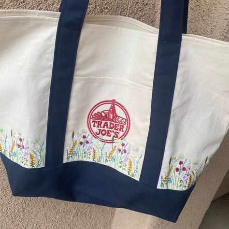 Trader Joe's Reusable Canvas Tote Bag Brand New With Tags . Trader Joe’s Blue And White Tote With Embroidered Logo. *** Added Bonus I Add The Flower Embroidery All Around The Bag, That Reflects The Pricing*** Price Firm I Promise You Will Get Compliments This Stylish And Heavy Duty Tote Is Perfect For Shopping, Great Library Book Bag, Pool Bag, Or Gym Bag. The Possibilities Are Endless With This Sturdy, Washable Bag From Everyone’s Favorite Grocery Store! With A Large Size Of 14in X 19in X 6in, Embroidery Trader Joe’s Bag, Trader Joes Bag Aesthetic, Trader Joes Tote Bags, Simple Tote Bag Painting, Embroidery On Tote Bags, Canvas Bag Embroidery, Embroidered Canvas Bag, Tote Embroidery, Tote Bag Embroidery