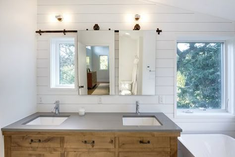 Barndoor Mirror : A solution to hang a mirror in front of a window.  We used an old metal door track and hung custom mirrors that slide to reveal the window and let in natural light or close for privacy and functionality.  Strand Design, Minneapolis, MN. Sliding Walls, Door Mechanism, Bathroom Mirror Design, Farmhouse Bathroom Design, Sliding Mirror, Urban Farmhouse, Modern Farmhouse Bathroom, Bathroom Windows, Girls Bathroom