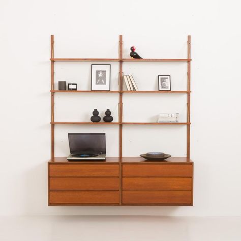 Scandinavian teak wall unit, designed in the 1960s, closely reminds poul cadovius or kai kristiansen's projects from the same period. This modular shelving system features two chests of drawers and six shelves, providing enough space for storage and books or decorations. All elements are 80 cm wide and can be arranged as needed using an easy mounting system of regular slots in the rails and brass hangers. the unit consists of:  - six shelves 20 cm deep  - two cabinets with 3 drawers h: 49 / w: 80 / d: 42 cm; drawers height: 10 cm  - three wooden wall rails 200 cm long  - brass hardware our team thoroughly checked the wall unit. The drawers are clean and work smoothly, and all parts fit together. We have renovated most of the elements. All parts have been sanded down and refinished with lay Mid Century Modern Shelving Unit, Wall Unit Shelving, Danish Shelving, Mid Century Shelves, Maroon Walls, Teak Wall Unit, Modular Shelving System, Laminate Wall, Dresser Shelves