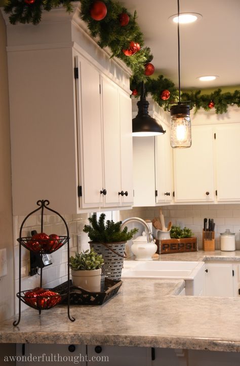 Upper Cabinets Christmas Decor, Festive Kitchen Decor, House Decorating Christmas, Christmas Garland Over Kitchen Cabinets, Christmas Garland On Top Of Cabinets, Christmas Decor Ideas For The Kitchen, Christmas Decor Top Of Cabinets, Christmas Decor On Windows, Christmas Decor Idea For Kitchen