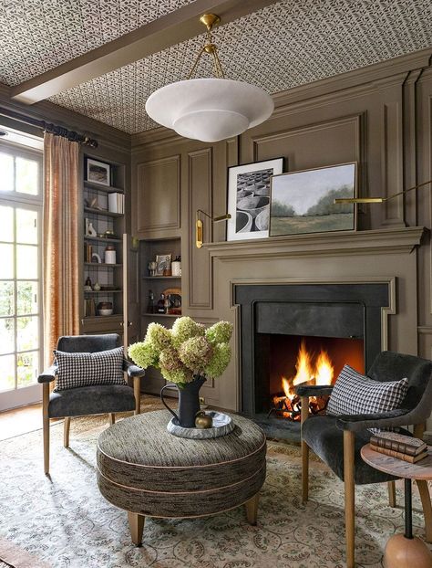 a living room with a fireplace Brown Sitting Room, Warm Brown Color Palette, Luxurious Library, Library With Fireplace, Office With Fireplace, Conservatory Design, Library Living Room, Fireplace Lighting, Chandelier Lights