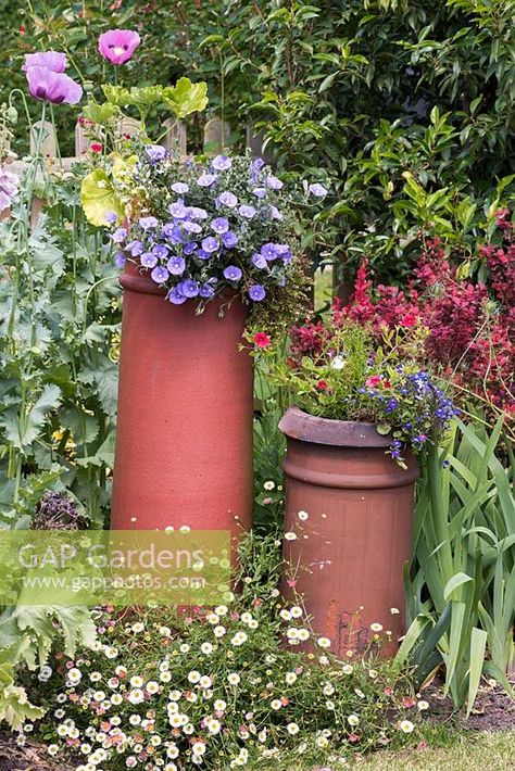 Two chimney pots planted colourful summer flowering plants create a focal point in a mixed border. Chimney Pot Planter Ideas, Chimney Pot Planter, Summer Flowering Plants, Chimney Pots, Garden Planters Pots, Garden Paradise, Garden Totems, Herbaceous Border, Pot Garden