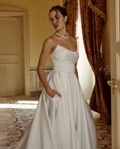 Quiet luxury is a Fiano A-line dress with a deep neckline decorated with silk drapery. For the bride’s comfort, we added hidden pockets on both sides. The model was created in order to feel like a queen on her most important day. The dress is perfect for a magnificent celebration outside the city, on the coast and in a luxurious banquet hall. #raragroup #raraavisgroup #fashion #weddingdress #wedding #weddingday #bride #couture #couturefashion #couturecollection Corset Style Wedding Dress, Wedding Dress Italy, Classic Bridal Look, Divine Atelier, White Wedding Dress, Long Train, Bridal Look, Bridal Robes, Online Wedding