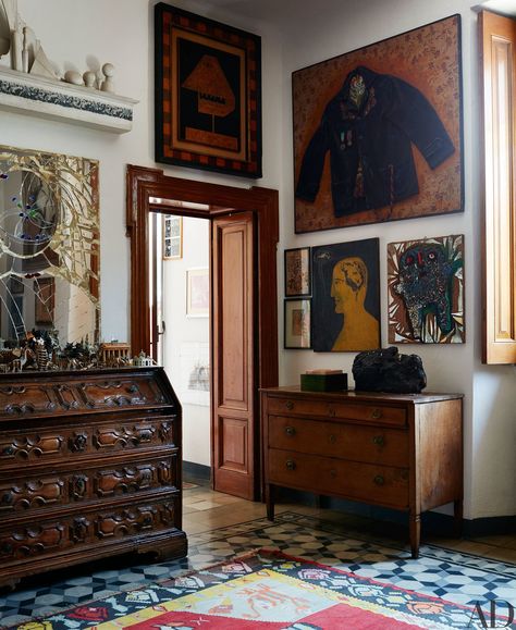 In a corner of the master bedroom, artworks, antique furniture, and colorful rugs and tile are layered in a collagelike effect not unlike many of Baj’s compositions, including The Rest of the Decorated Man, which hangs at top right. Art Nouveau Desk, Art On The Wall, White Furniture Living Room, Italian Villa, White Living, A Living Room, Architectural Digest, Rustic Furniture, Antique Furniture