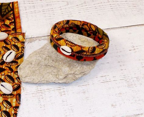 Ce bracelet de style africain est réalisé en tissu wax il se compose de 2 rangs et il est brodé la main de petites perles de rocaille miyuki de couleur bronze, et agrémenté d'un coquillage cauri. il convient à un poignet de 18cm. le bracelet est souple, facile à mettre et à retirer. ce bracelet aux couleurs "safari" sera parfait avec toutes vos tenues : saharienne, teeshirt etc. entretien: ne pas se baigner avec le bracelet, enlever les éventuelles taches avec une éponge humide. Style Africain, Leather Bracelet, Wax, Bracelet, Leather