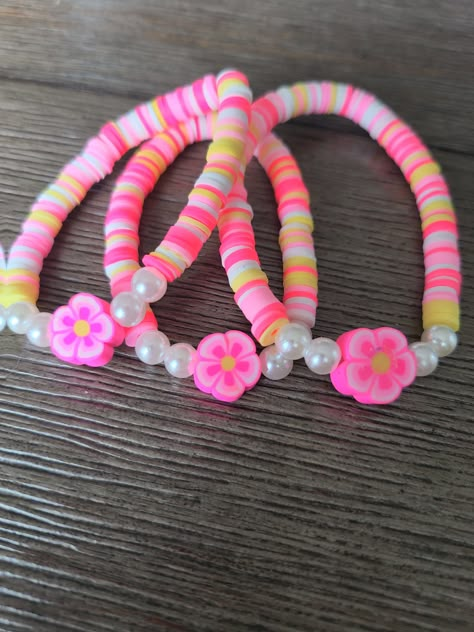 Bright pink, pastel pink, yellow, and white with a super cute pink hibiscus charm. Perfect for a tropical summer vibe! Bracelets Preppy, Make Clay Beads, Colorful Bead Bracelets, Rainbow Loom Bands, Clay Bead Necklace, Diy Beaded Rings, Preppy Bracelets, Homemade Bracelets, Bracelet Inspo