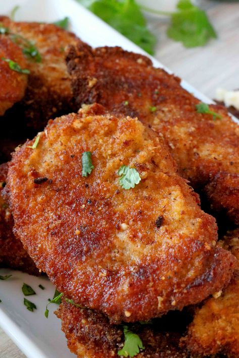 A close up shot of Parmesan Crusted Pork Chops with parsley sprinkled over the top. Parmesan Crusted Pork Loin, Parmasean Crusted Pork Chop, Garlic Crusted Pork Chops, Extra Crispy Pork Chops, Parmesan Fried Pork Chops, Pablo Crusted Pork Chops, Top Loin Pork Chops, Pork Parmesan Recipe, Pork Chop Center Cut Recipes