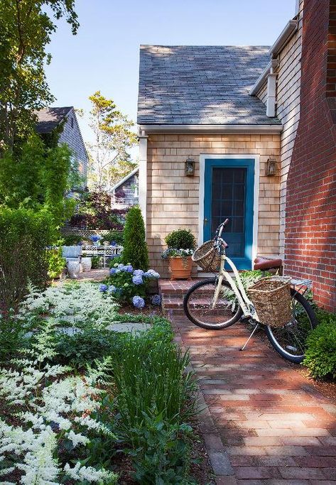 Red brick pavers lead to a shingled cottage home accented with a blue Front door. Shingled Cottage, Cottage Home Exterior, Red Brick Pavers, Navy Blue Houses, Cottage House Exterior, Nantucket Cottage, Shingle House, Nantucket Home, Blue Front Door