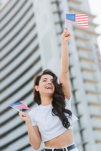 Low angle woman holding two usa flagsand smiling Free Photo Character Holding Flag Reference, Flag Poses, Person Holding Flag, Pictures With Flags Photo Shoot, American Flags Photography, Usa Wallpaper, Australian Flags, Small Flags, Lgbtq Flags