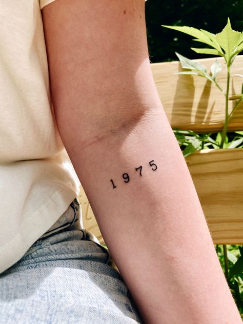 #1975 #the1975 #1975tattoo #tattoos #tattoosforwomen #armtattoo #womansleevetattoo #minimalisttattoos #hipstertattoos #yeartattoo #aesthetictattoos 1998 Small Tattoo, 1975 Number Tattoo, 1968 Tattoo Font, Somebody Else The 1975 Tattoo, Tattoo Ideas Female Birth Year, 1983 Tattoo Ideas, Year Tattoo On Arm, 1965 Tattoo Number, 1973 Tattoo Ideas