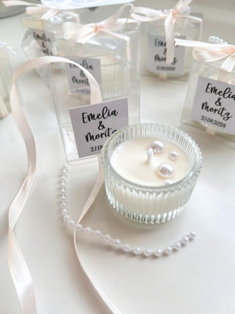 We are so excited to introduce these beautiful soy wax candles, the perfect addition to so many events such as weddings, baptisms, bridal showers and engagements. We make each candle individually from soy wax, and they make such lovely party favors for your special occasions. Our soy wax candles* with beads are presented in elegant 4 cm glass candle holders, with the box measuring 5 x 5 x 5 cm. They come in a variety of colors including pastel pink, pastel blue, white, green and mint. With our selection of customizable bows, you're sure to find the perfect design to suit your individual taste. Production times vary depending on order volume. Orders of up to 50 units will be ready to ship within 3-5 business days. Larger volume orders may require a longer production time of 7-10 days to ens Pastel Wedding Favors, Pearls And Prosecco Bridal Shower Favors, Affordable Bridal Shower Favors, Engagement Party Gifts For Guests, Bridal Shower Party Favors Ideas, Pearls And Processo Bridal Shower Theme, Wedding Gifts For Guests Elegant, Pearls Bridal Shower Theme, White Bridal Shower Decor