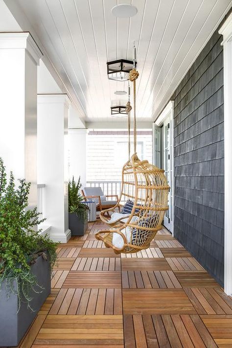 Rattan chairs hang from a white shiplap porch ceiling over teak floor tiles lit by glass and oil rubbed bronze flush mounts. Home Bunch, Home Improvement Loans, Diy Outdoor Decor, Front Patio, House With Porch, Porch Design, Interior Modern, Modern Coastal, Diy Patio