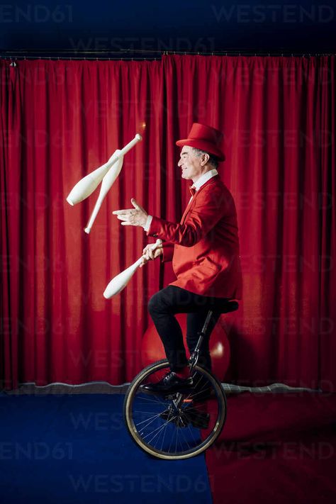 Male artist juggling pins while balancing on unicycle in circus – Stockphoto Ringmaster Aesthetic, Unicycle Circus, Circus Moodboard, Circus Juggler, Juggling Pins, Circus Entertainment, Vintage Circus Performers, Circus People, Modern Circus