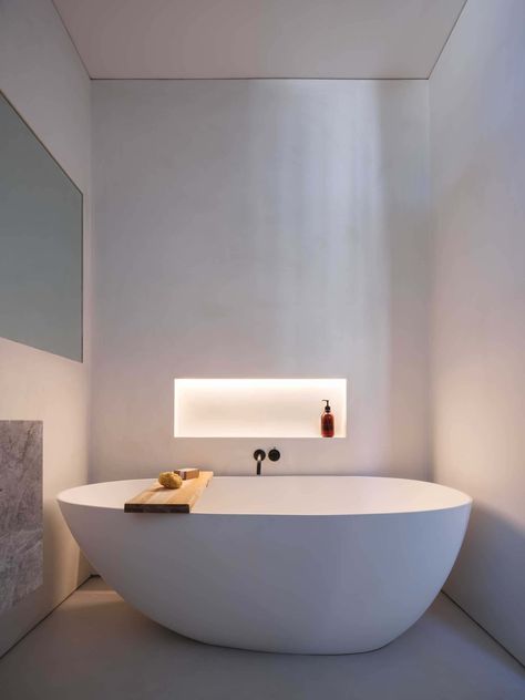 This modern bathroom has a shelving niche by the bathtub. Hidden LED lighting has been included, which when turned on, creates a soft glow and adds to the calm atmosphere of the bathroom. Bath Niches Bathtubs, Bathtub With Bench, Bathroom Ambient Lighting, Bathtub Lighting Ideas, Bathtub Niche Ideas, Bath Tub Lighting, Bathtub Niche, Niche In Wall, Bathtub Lighting