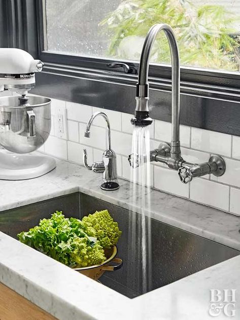 An undermount stainless-steel sink paired with a farmhouse-inspired faucet continues the kitchen's modern-meets-vintage vibe. Black window trim adds drama to the white countertops and backsplash. Small Traditional Kitchen, Classic Contemporary Kitchen, Replacing Kitchen Countertops, Undermount Stainless Steel Sink, Best Kitchen Sinks, Modern Kitchen Sinks, Kitchen Sink Design, Sink Ideas, Kitchen Sink Faucets