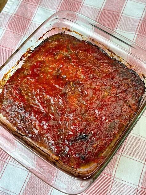 Overhead view of 9 x 9 inch square baking dish with a layer of brown sugar and ketchup sauce on top of a red and white plaid napkin. Amish Meatloaf Recipe, Meatloaf With Oats, Amish Meatloaf, Hamburger Meat Dishes, Ground Beef Meatloaf, Tasty Meatloaf Recipe, Meat Loaves, Bacon Meatloaf, Amish Food